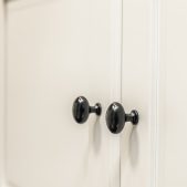 Black knobs on white cabinet doors